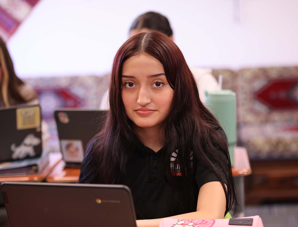 Elementary student smiling and posing together in a classroom.